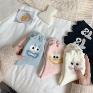 Detailed close-up of thick camel hair socks with cute cartoon embroidery and wavy cuffs