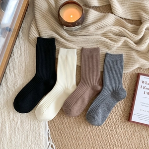 Detailed knit texture of four-color ribbed crew socks arranged in a warm home setting