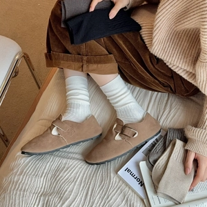 Close-up of retro brown suede loafers styled with knit crew socks for autumn wear