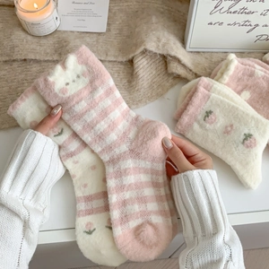 Gros plan de chaussettes épaisses en polaire corail rose fraise avec motifs de lapin doux
