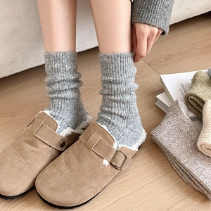Detail of camel suede clogs with thick faux shearling lining and cozy wool socks