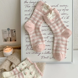 Détail de chaussettes en polaire fraise rose avec oreilles de lapin sur maille douce