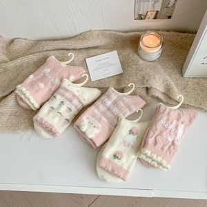 Détail de chaussettes épaisses en polaire rose avec fraises et oursons 3D mignons
