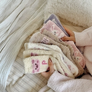 Gros plan de chaussettes en polaire corail douce avec broderie de lapin et d'ours