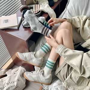 Detail of striped cotton crew socks in various colors paired with classic white sneakers