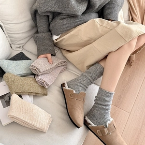 Detail of warm wool socks in assorted colors with a textured rib-knit and cozy aesthetic