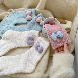 Detail of soft coral fleece plush socks featuring 3D knitted bows and cozy texture