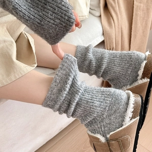 Detail of grey knitted wool socks with thick ribbed texture in a cozy indoor setting