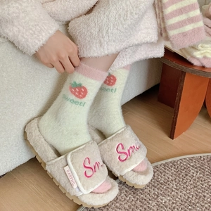 Dettaglio calze in pile corallo fragola con morbide pantofole beige con sorriso