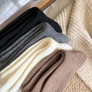 Close-up of thick ribbed knit socks in black, grey, beige and mocha on soft fleece fabric
