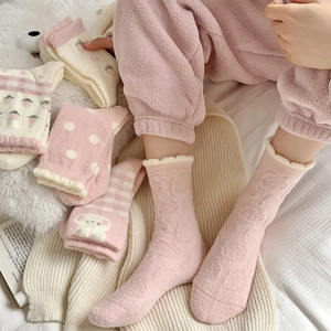 Gros plan détaillé de chaussettes épaisses en polaire rose avec motifs fraise et ours
