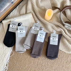 Cozy lifestyle flat lay of five pairs of ribbed cashmere-feel men's crew socks