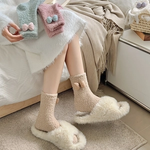 Detailed view of cozy coral fleece home socks featuring 3D bows in cream, mint, and pink
