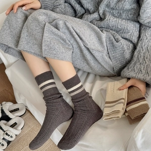 Detailed close-up of thick ribbed knit wool socks with classic double stripe cuff design