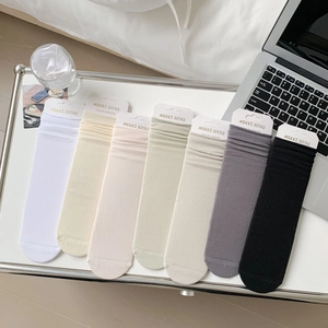 Detail shot of seven pairs of pastel ribbed cotton socks in a cozy home office setting