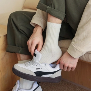 Close-up of off-white ribbed knit crew socks showing soft texture and cozy fit on feet