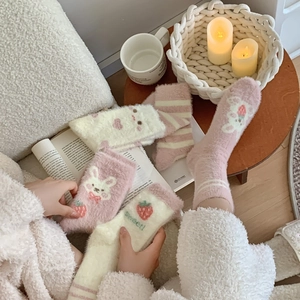 Dettaglio calze in pile corallo fragola rosa con consistenza soffice e motivi a coniglio