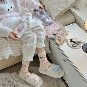 Détail de chaussettes épaisses en polaire corail avec oursons et pantoufles en peluche