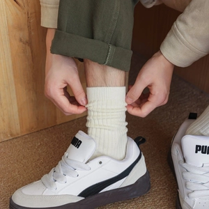 Detail shot of warm cream ribbed cotton crew socks for men in a cozy home setting