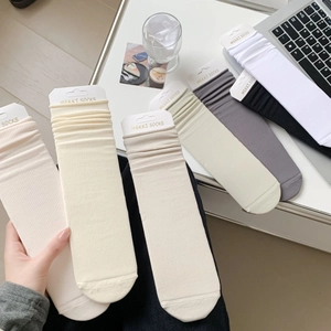 Detailed view of knitted vertical ribbed crew socks in various neutral cotton tones