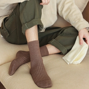 Detailed knit texture of rib-knit crew socks in brown and off-white colors