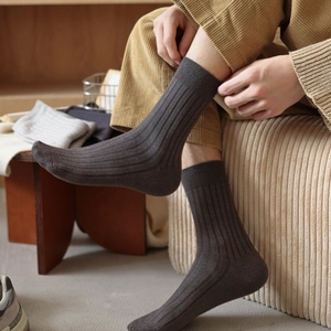 Detail of dark brown ribbed cashmere-like socks with thick warm texture for men