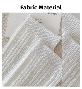 Detail of white ribbed knit fabric texture on cotton crew socks with soft lighting