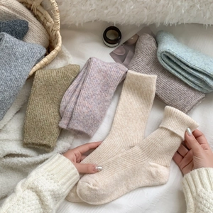 Detailed knit texture of thick wool socks in various colors on a plush background