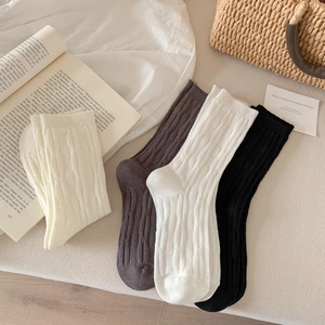 Close-up of ribbed vertical knit pattern on cotton blend crew socks in neutral tones