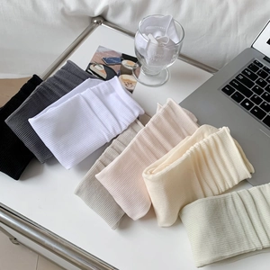 Flat lay of colorful ribbed combed cotton mid-calf socks for women in soft macaron tones