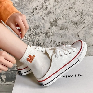 White cotton socks with orange M embroidery paired with casual canvas mule sneakers