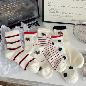 Détail de chaussettes en coton crème avec motifs à rayures et broderie de chien