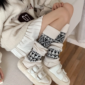 Detail of Nordic pattern knitted leg warmers styled with pleated skirt and slippers