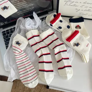Gros plan détaillé de chaussettes en coton avec broderie chien et motifs rayés