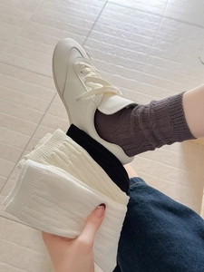 Close-up of vertical cable knit texture and breathable mesh on stylish mid-calf cotton socks