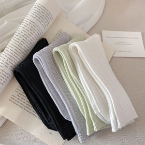 Detail of mesh knit cotton socks in black, grey, green, and white colors with rib texture