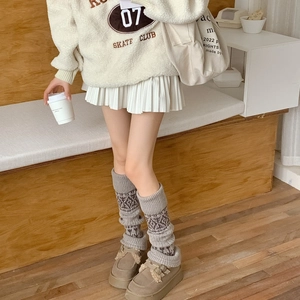 Fair Isle pattern leg warmers paired with suede loafers and a white pleated skirt