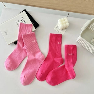 Detailed shot of pink cotton crew socks with DO IT text and ribbed knit texture