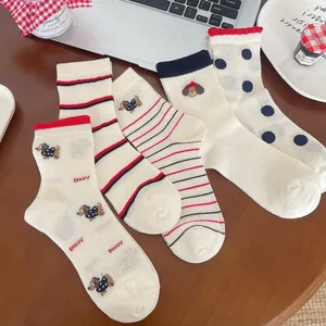 Gros plan de chaussettes en coton mesh respirant avec rayures et motifs de chiens mignons