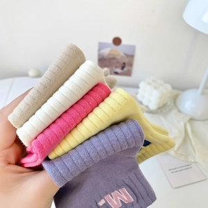 Close-up of ribbed cotton sports socks with M embroidery and textured knitting detail