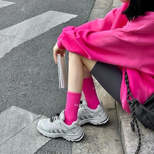 Street style shot of vibrant magenta crew socks with sneakers and a matching hoodie