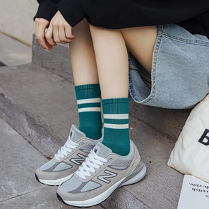 Women's dark green mid-calf cotton socks with white stripes paired with retro sneakers