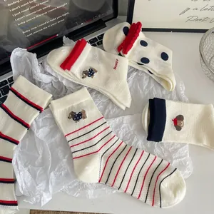 Détail de chaussettes en coton avec broderie de chien et motifs en maille rayée