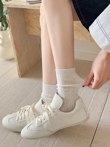 Close-up of breathable white ribbed crew socks with high elasticity and mesh texture