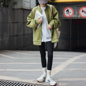 Detail of olive green bomber jacket with embroidery and striped socks set