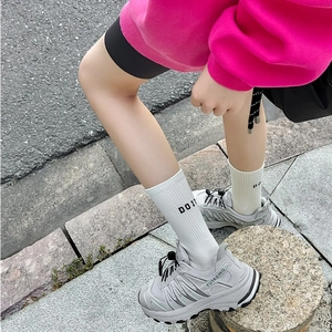 Detailed side view of thick-soled grey dad sneakers with breathable mesh and DO IT socks
