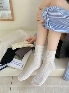 Detail of cable knit texture and rolled cuff on vintage style cotton mid-calf socks