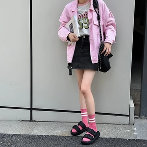Close-up of pink-white striped mid-tube socks with black platform sandals and denim skirt