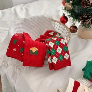 Detail of red and green Christmas socks with festive knit patterns and ribbed cuffs