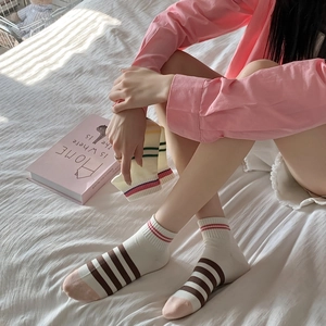 Detail of striped combed cotton ankle socks featuring ribbed cuffs and colorful accents